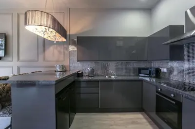 a kitchen with black and white cabinets and a chandelier at Manhattan Suite - sleeps 24! Heart of Liverpool in Liverpool