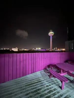 a purple wall with a picnic table and a water tower at Penthouse Apartment, Sleeps 21 with terrace in Liverpool