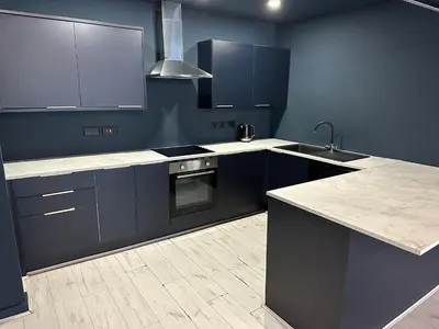a kitchen with blue cabinets and a sink and a stove at Unique city centre DJ apartment - sleeps 20 in Liverpool