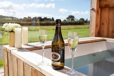 a bottle of wine and two glasses on a ledge at High Longlands in Cartmel