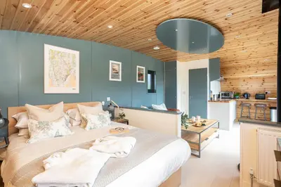 a bedroom with a large bed and a wooden ceiling at High Longlands in Cartmel