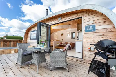 a tiny house with a patio and a grill at Little Heaning in Cartmel