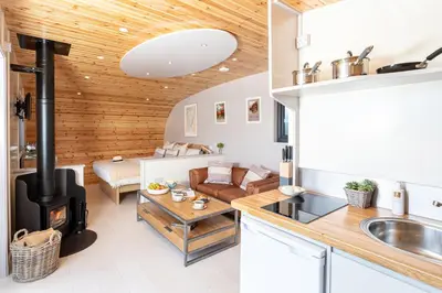 a kitchen and living room with a woodburning stove at Little Heaning in Cartmel