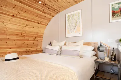 a bed in a room with a wooden ceiling at Little Heaning in Cartmel