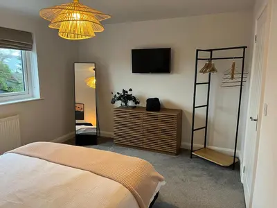 a bedroom with a bed and a television on the wall at Close to Lytham, Blackpool, Ribby Hall & BAE in Warton