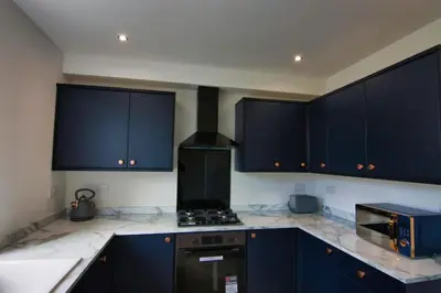 a kitchen with blue cabinets and a stove top oven at Close to Lytham, Blackpool, Ribby Hall & BAE in Warton