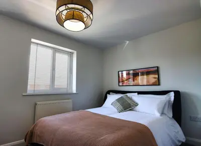 a bedroom with a bed with a lamp and a window at Close to Lytham, Blackpool, Ribby Hall & BAE in Warton