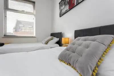 a bedroom with two beds and a window at No 1 School House in Leyland