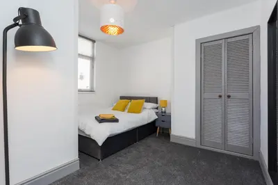 a bedroom with a bed with yellow pillows at No 1 School House in Leyland