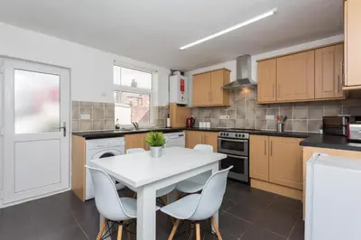 a kitchen with a white table and chairs at No 1 School House in Leyland