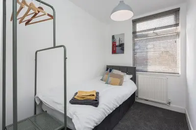 a small bedroom with a bed and a mirror at No 1 School House in Leyland
