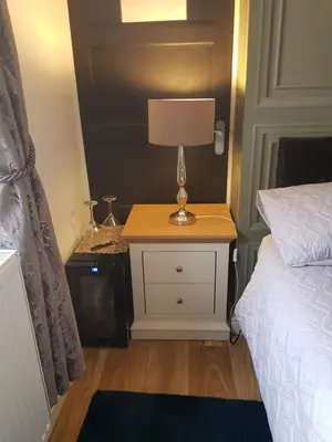 a bedroom with a bed and a lamp on a night stand at Sea-Quinn Views in Wallasey