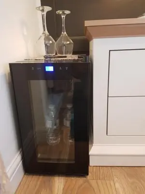a microwave oven with two glasses on top of it at Sea-Quinn Views in Wallasey