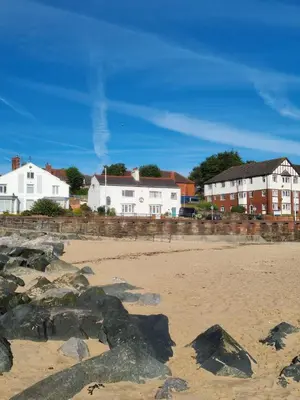 a sandy beach with houses and buildings in the background at Sea-Quinn Views in Wallasey
