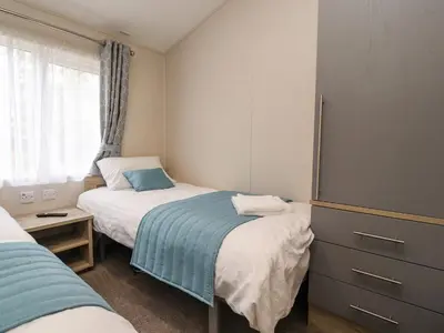 a small bedroom with two beds and a window at Fountain View in Carnforth