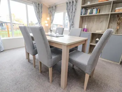 a dining room table with gray chairs and a table at Fountain View in Carnforth