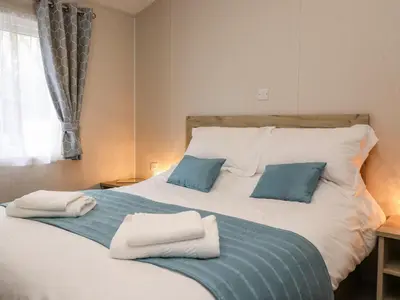 a bedroom with a large bed with towels on it at Fountain View in Carnforth