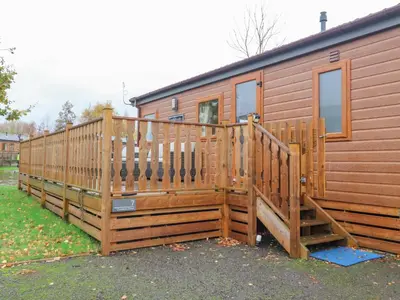 a wooden cabin with a large wooden deck at Fountain View in Carnforth