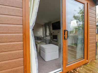 a sliding glass door to a living room with a couch at Fountain View in Carnforth