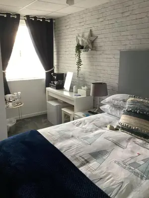 a bedroom with a bed and a desk and a window at By the Seaside in Blackpool