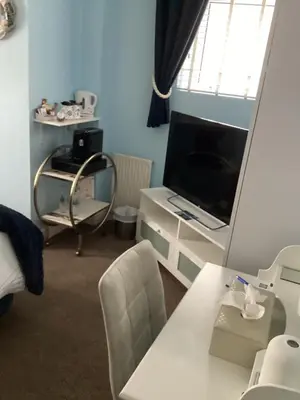 a living room with a television and a table and chairs at By the Seaside in Blackpool