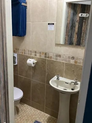 a bathroom with a sink and a toilet and a mirror at By the Seaside in Blackpool