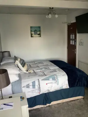 a bedroom with a bed with a blue and white blanket at By the Seaside in Blackpool