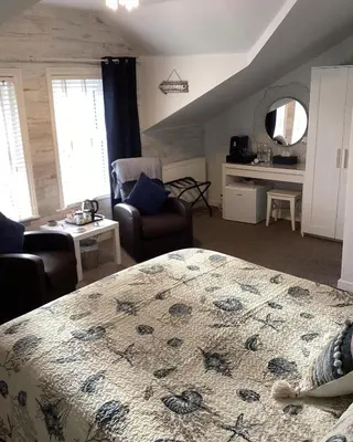 a bedroom with a bed and a living room at By the Seaside in Blackpool