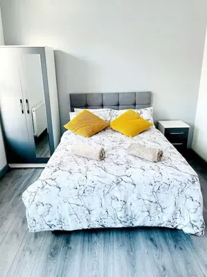 a bedroom with a large bed with two yellow pillows at Entrepreneur Stays - 8 Guest house in Liverpool