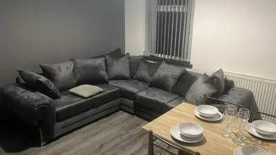 a cat sitting on a couch in a living room at Entrepreneur Stays - 8 Guest house in Liverpool