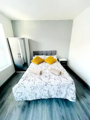 a bedroom with a large bed with yellow pillows at Entrepreneur Stays - 8 Guest house in Liverpool