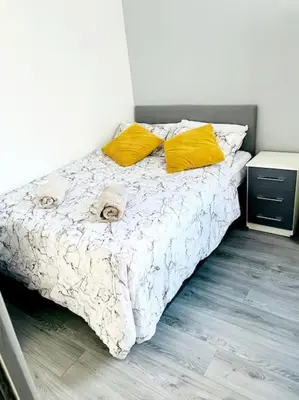 a bedroom with a bed with two yellow pillows at Entrepreneur Stays - 8 Guest house in Liverpool