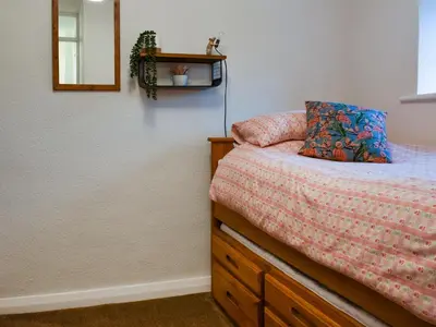 a bedroom with a bed with a dresser and a mirror at Shire Nooks in Hurst Green