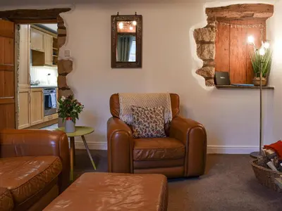 a living room with a chair and a table at Shire Nooks in Hurst Green