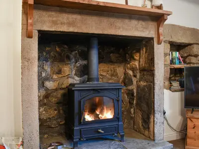 a stove in a stone fireplace in a room at Shire Nooks in Hurst Green