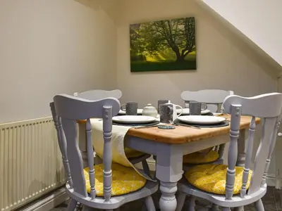 a dining room table with four chairs around it at Shire Nooks in Hurst Green