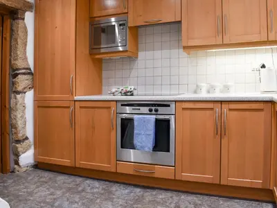 a kitchen with wooden cabinets and a stainless steel oven at Shire Nooks in Hurst Green