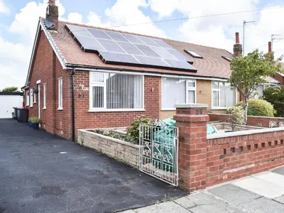 a brick house with solar panels on the roof at Newcastle Lodges in Thornton