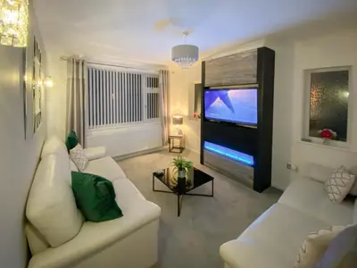 a living room with a white couch and a flat screen tv at Newcastle Lodges in Thornton