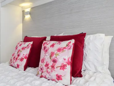 a bed with red and white pillows on it at Newcastle Lodges in Thornton