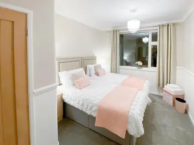 a bedroom with a bed with pink pillows and a window at Newcastle Lodges in Thornton