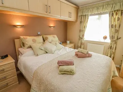 a bedroom with a bed with two towels on it at Mallard Lodge in Carnforth