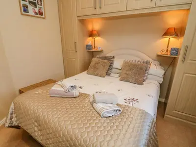 a bedroom with a bed with two towels on it at Mallard Lodge in Carnforth