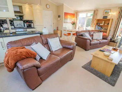 a living room with two brown leather couches and a table at Mallard Lodge in Carnforth