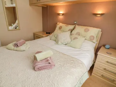 a bedroom with a large bed with towels on it at Mallard Lodge in Carnforth
