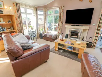 a living room with a couch and a television at Mallard Lodge in Carnforth