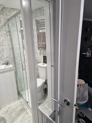 a bathroom with a toilet and a glass shower door at Lovely unit elgin drive Coastal Bliss Your Seaside Retreat with City Excitement in Wallasey