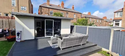a house with a deck with two chairs on it at Lovely unit elgin drive Coastal Bliss Your Seaside Retreat with City Excitement in Wallasey