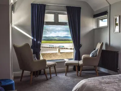 a room with a window with chairs and a bed at Ted's Place in Arnside