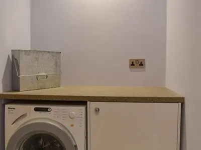 a kitchen with a washing machine and a counter at Ted's Place in Arnside